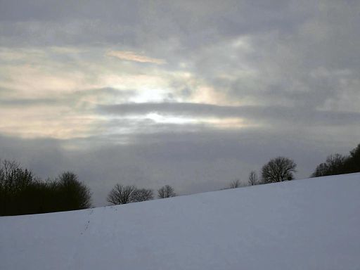 Sonne leuchtet durch Schneewolken